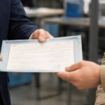 O que significa o termo "nada consta criminal" na certidão de antecedentes criminais? 3 Delegado entregando uma certidão a um cidadão dentro de uma delegacia, em ambiente institucional moderno e bem iluminado, com composição realista e foco na interação entre os personagens.