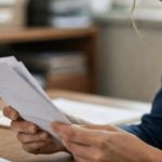 Qual é o prazo para abertura de inventário? 1 um funcionário analisando um documento em cartório, em plano médio com iluminação natural suave